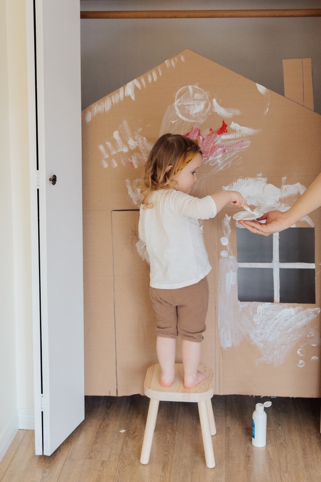 Child painting a Wendy House