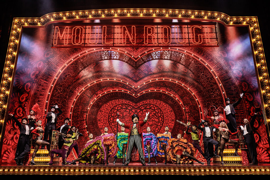 Cameron Blakely as Harold Zidler and the original world tour company of Moulin Rouge! The Musical Photo credit – Matt Crockett