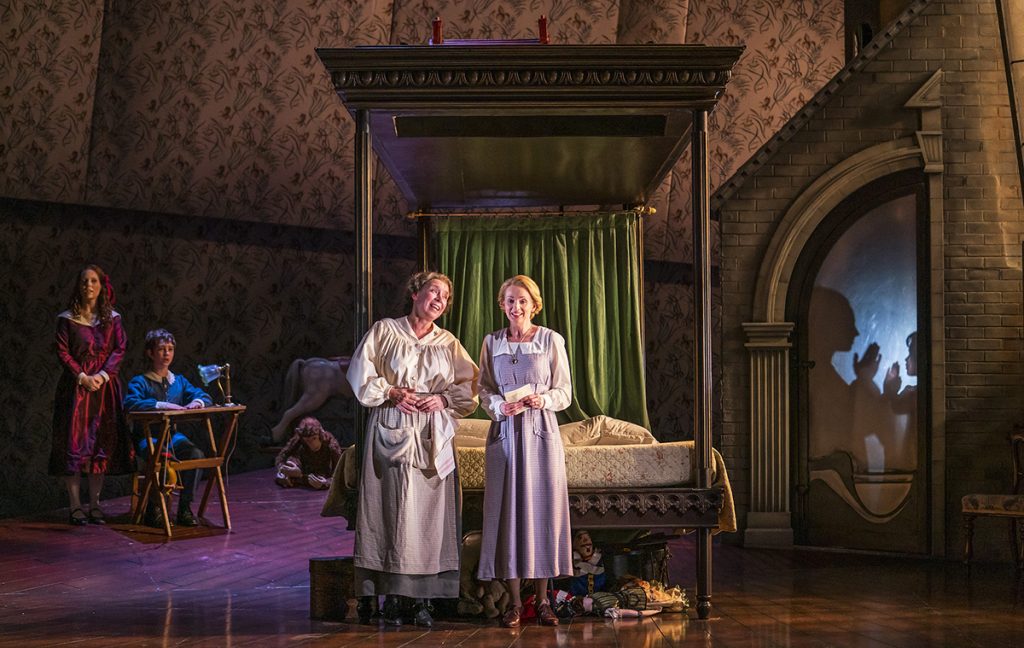 Opera North’s production of Britten’s The Turn of the Screw  Jennifer Clark as Flora, Tim Gasiorek as Miles, Heather Shipp as Mrs Grose and Sarah Tynan as The Governess. Photo credit: Tristram Kenton