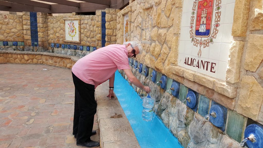 Lorraine's husband,  Bob filling water bottles from the fresh water Chorros Square in Polop Village